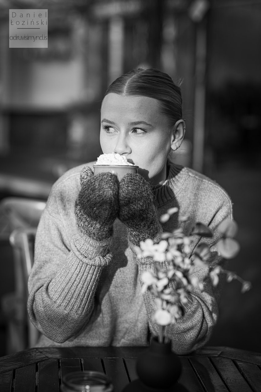 Svarthvít mynd af konu að drekka heitt súkkulaði. Andlitsmyndataka. Mynd tekin í garði í Reykjavík. Ljósmyndari - Daniel Łoziński. Myndavél Nikon D850. Linsa Sigma ART 85mm.