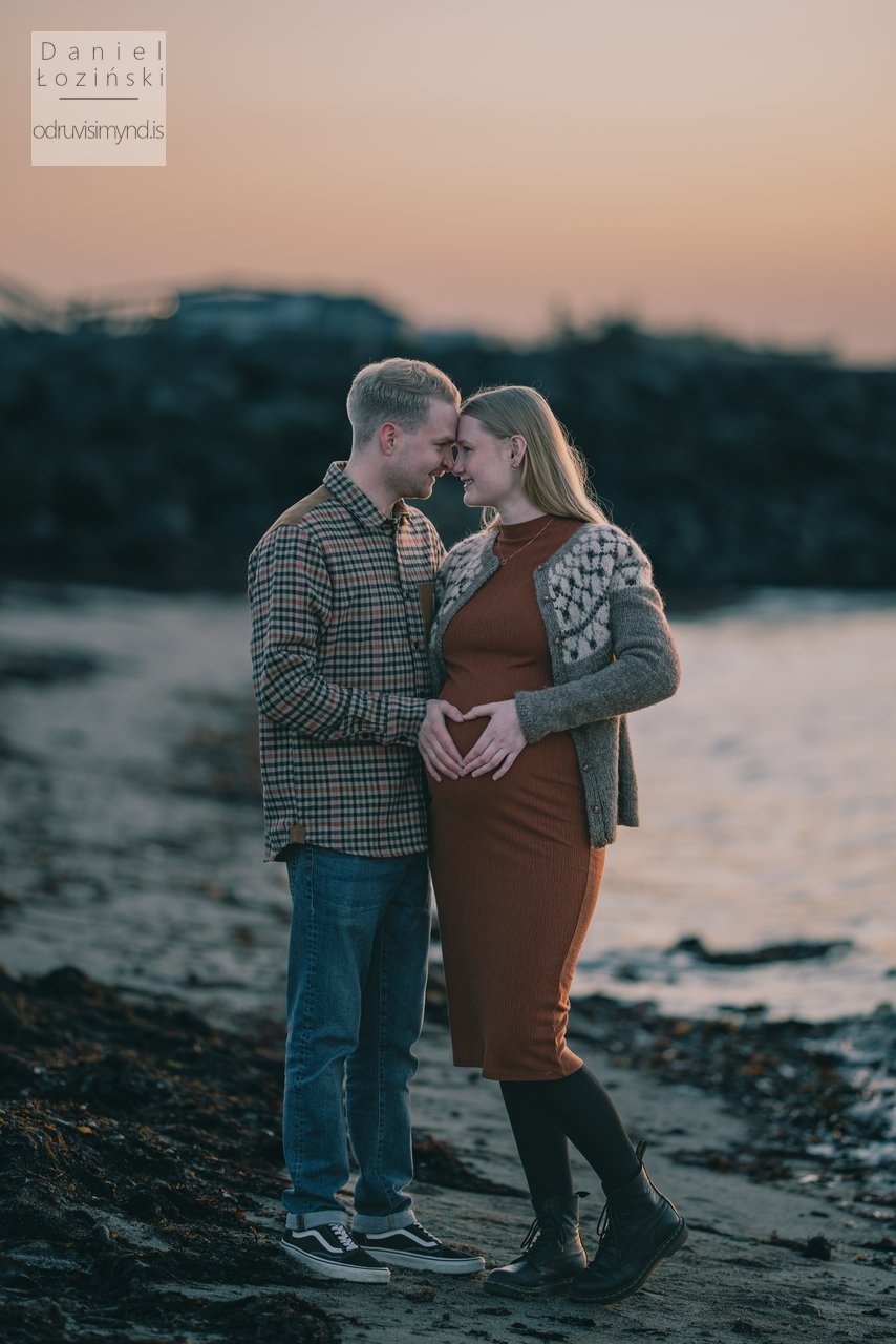 Mynd af pari á ströndinni. Meðgönguljósmyndun. Meðgöngumyndatöku. Óléttumyndataka. Sólsetur. Mynd tekin með Nikon myndavél og Sigma ART linsu. Ljósmyndari - Daniel Łoziński. Ljósmyndafundur í Reykjavík.